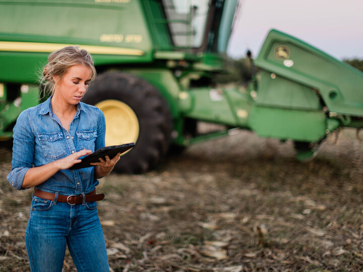 Woman looking at digital tablet in a corn field