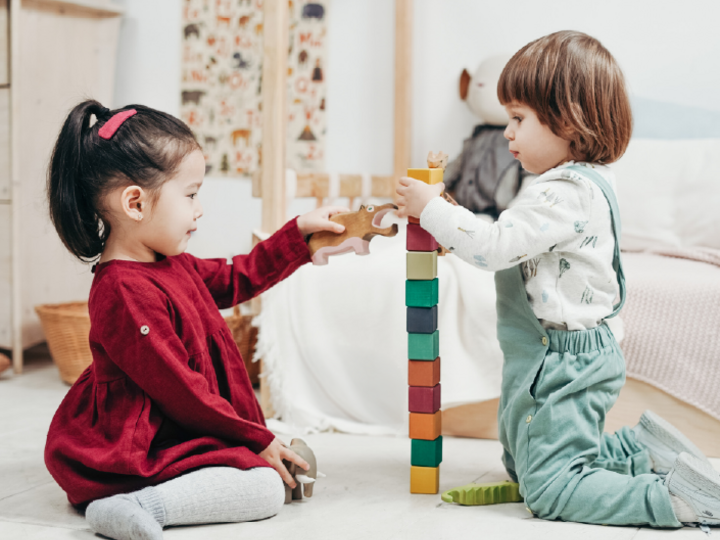 two children building a tower of blocks