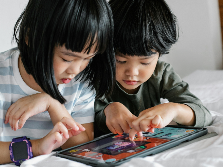 Two children working on a digital device