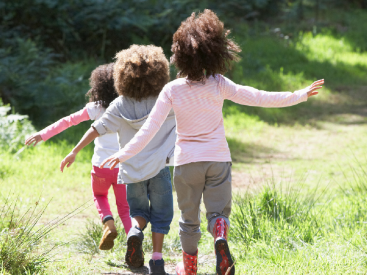 Three children walking on a pathway outdoors