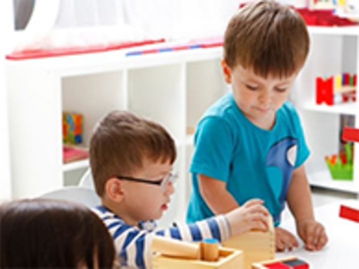 Two young children stacking blocks