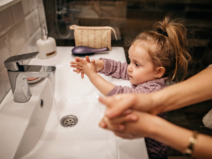 Young child washing hands at a bathroom sink