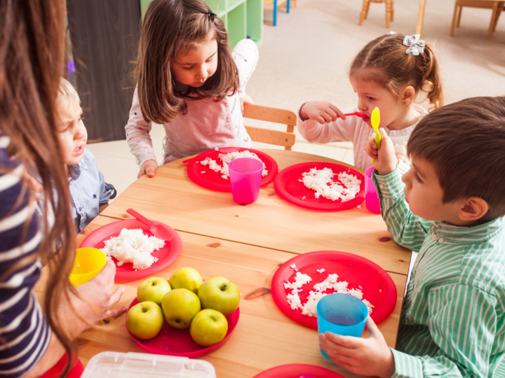 Children eating family style around a table
