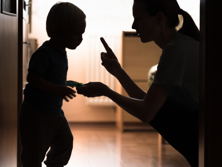 Young mother kneeling and talking with young toddler child.