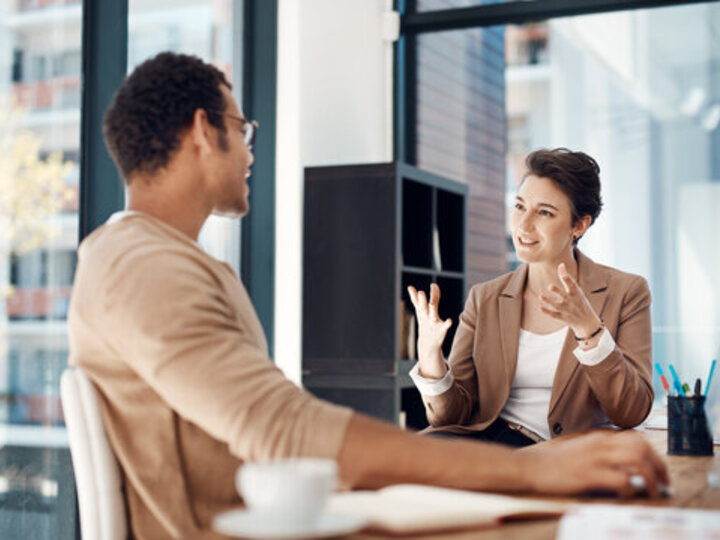 Two adults sitting at work having a conversation