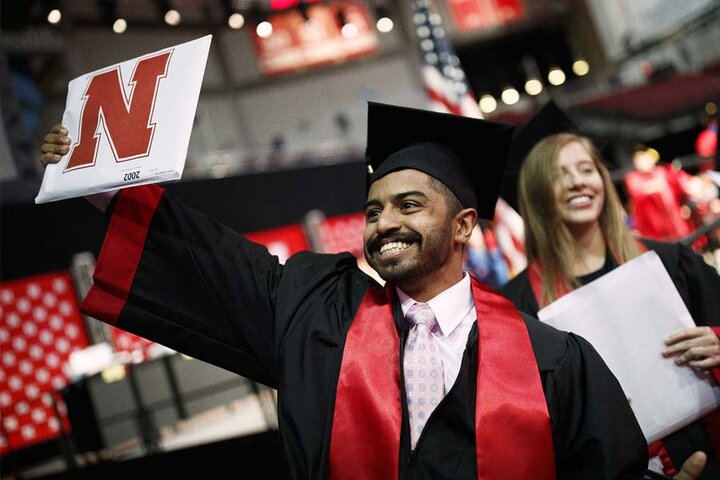 Undergraduate student holding up degree
